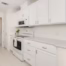 Remodeled kitchen featuring painted cabinets, white quartz countertops, subway tile backsplash, and updated appliances.